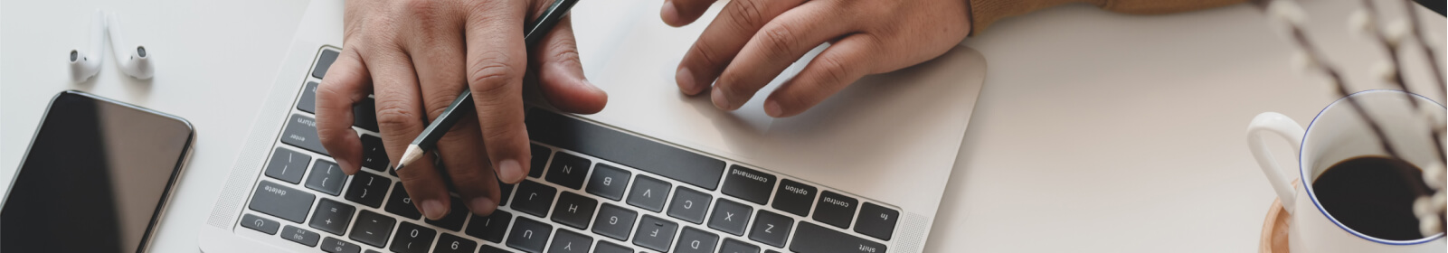 Hands typing on laptop at desk